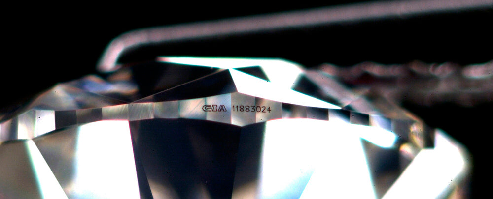 Laser inscription on a diamond girdle showing the GIA report number for physical identification.